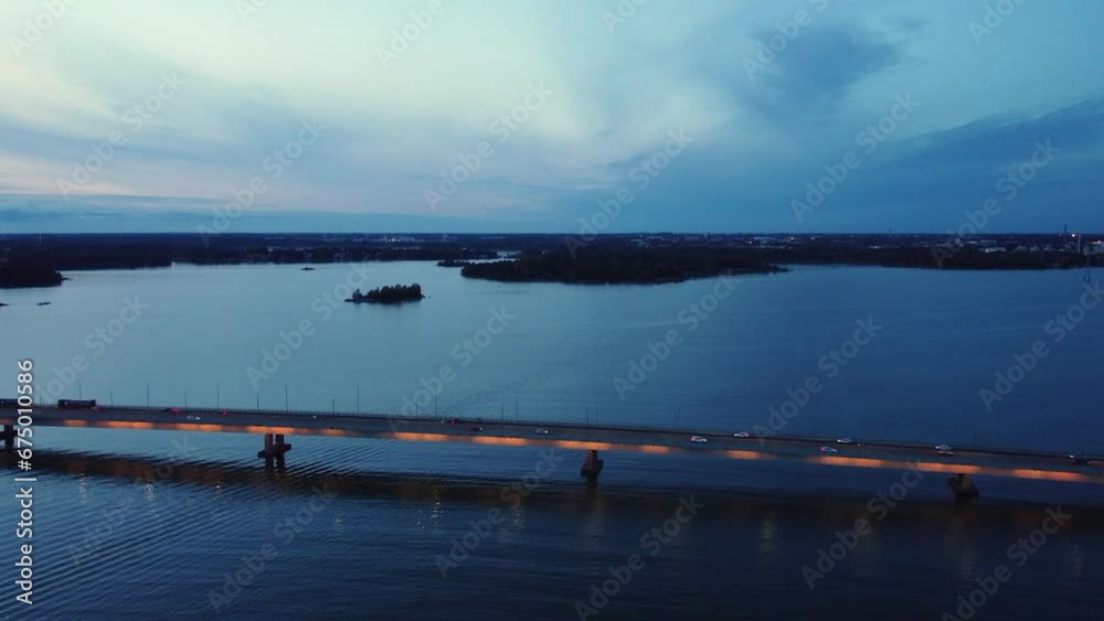 Evening vehicle traffic crosses illuminated bridge at dusk blue hour Evening vehicle traffic crosses illuminated bridge at dusk blue hour