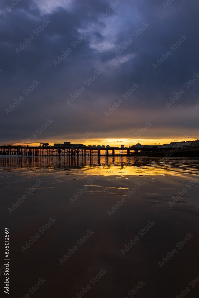 Scenic view of the sun rising over a pier jutting into a body of water