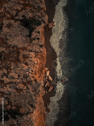 top view aerial of sea waves at night and rocky shore