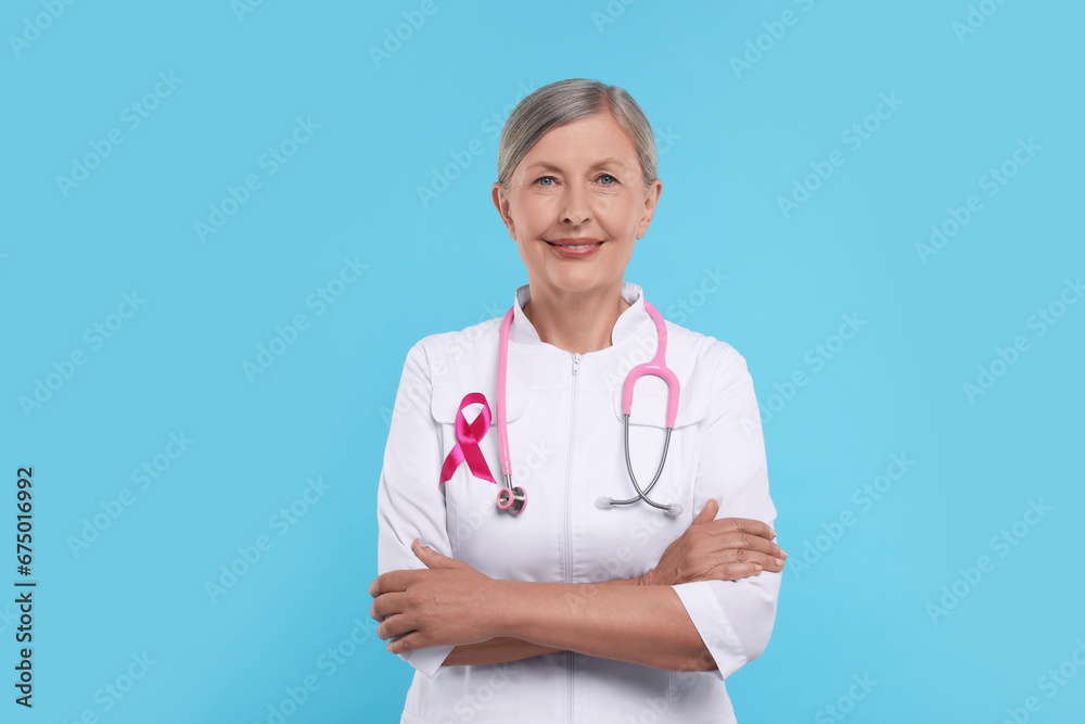 Doctor with pink ribbon and stethoscope on light blue background. Breast cancer awareness Doctor with pink ribbon and stethoscope on light blue background. Breast cancer awareness
