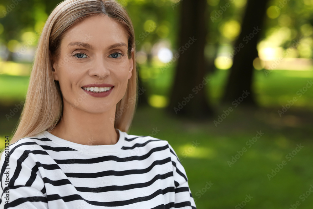 Portrait of happy woman in casual clothes outdoors. Space for text. Attractive lady smiling and posing for camera Portrait of happy woman in casual clothes outdoors. Space for text. Attractive lady smiling and posing for camera