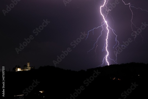Scenic view of a lightning strike in hills at night