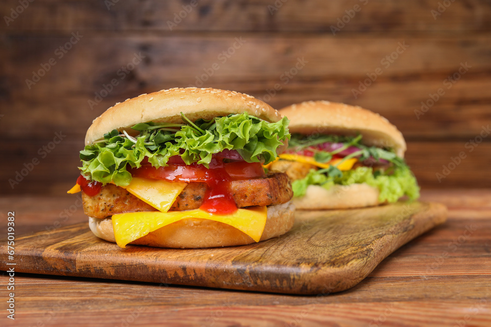 Delicious burgers with tofu, fresh vegetables and sauce on wooden table Delicious burgers with tofu, fresh vegetables and sauce on wooden table
