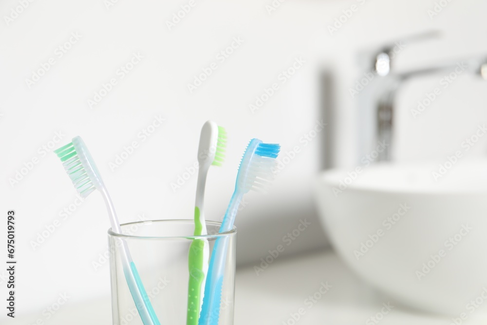 Plastic toothbrushes on blurred background,, closeup. Space for text