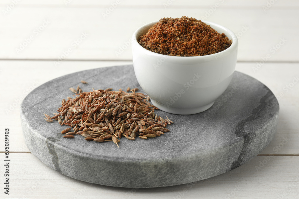 Caraway (Persian cumin) seeds and powder on white wooden table