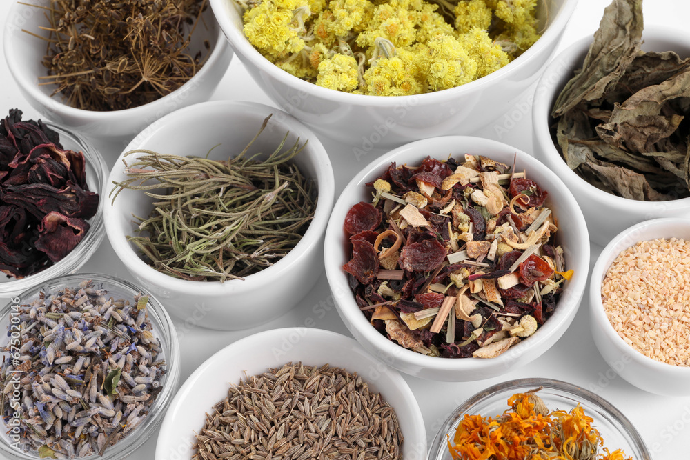 Many different dry herbs and flowers in bowls on white background Many different dry herbs and flowers in bowls on white background