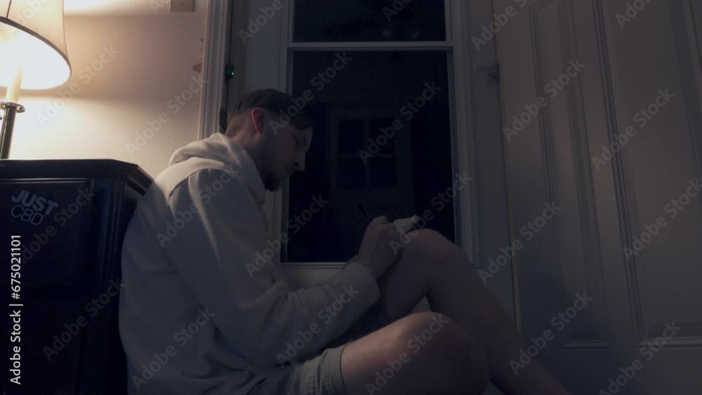 Lightning strikes through the window as a man writes in a notebook beneath a lamp at night. Lightning strikes through the window as a man writes in a notebook beneath a lamp at night.