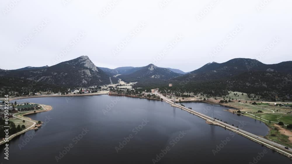 Drone view over a pond reservoir between rural fields and a residence with a background of hills Drone view over a pond reservoir between rural fields and a residence with a background of hills