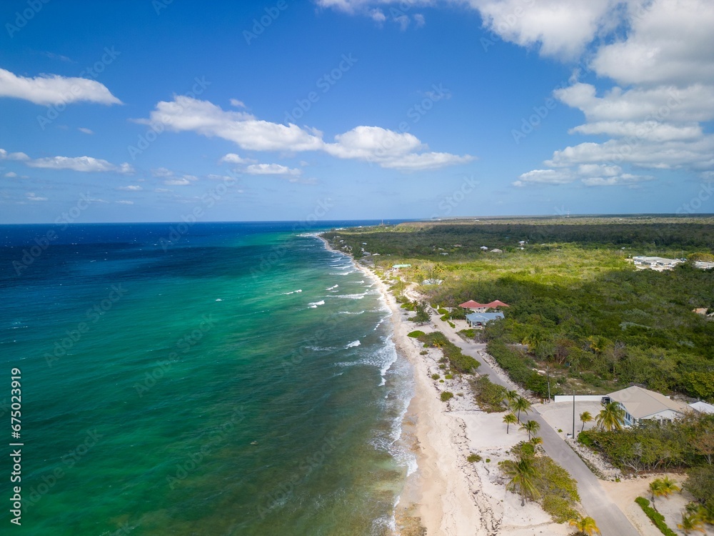View of a tropical white sand beach surrounded by crystal clear water , North Coast of Cayman Brac View of a tropical white sand beach surrounded by crystal clear water , North Coast of Cayman Brac