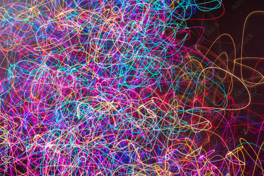 Abstract light painting of multiple bright, glowing neon colors, with a chaotic squiggle pattern that begins to trail off toward the right edge of the image.