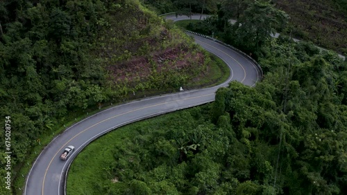 Drone view over curved roads between forested landscapes