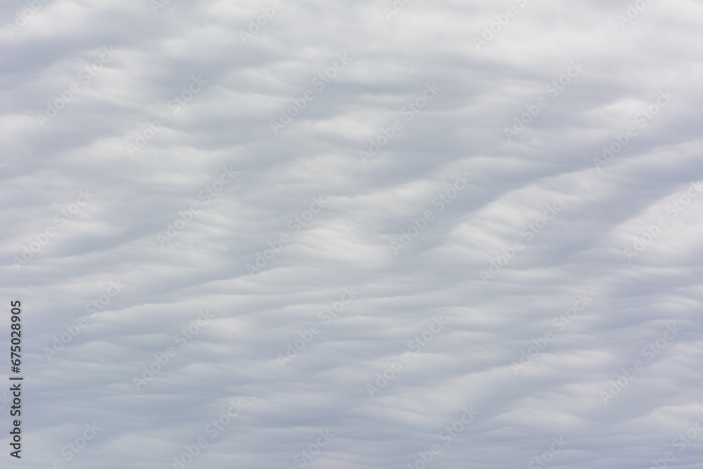 Fototapeta premium Abstract cloud texture with a wavy, sand dune pattern.