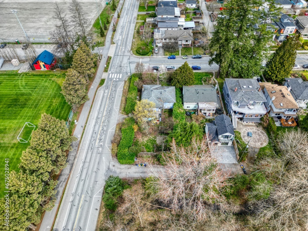 Naklejka premium Aerial view of a vibrant suburban neighborhood in North Vancouver, featuring lush trees and greenery