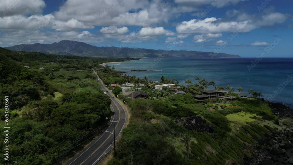 Waimea Bay, O'ahu, Hawaii during the day by a drone with wind turbines, churches, mansions, and rock Waimea Bay, O'ahu, Hawaii during the day by a drone with wind turbines, churches, mansions, and rock
