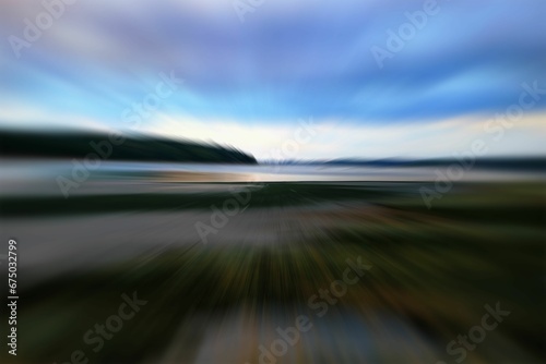 blurry photograph of the beach and river in front of a body of water