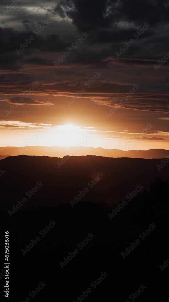 Beautiful sunset over a hilly valley bathed in a warm orange glow