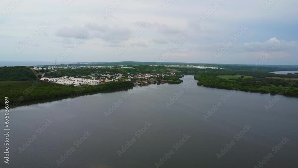 Aerial drone forward moving shot over resort buildings alongside Mandinga Lagoon mangrove area, Veracruz in Mexico during kayak trip. Aerial drone forward moving shot over resort buildings alongside Mandinga Lagoon mangrove area, Veracruz in Mexico during kayak trip.
