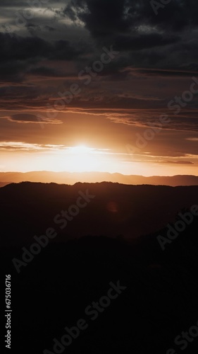 Beautiful sunset over a hilly valley bathed in a warm orange glow