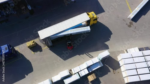 Aerial view of a semi trucks with cargo trailers standing on warehouses ramps for loading unloading goods on the big logistics park with loading hub photo