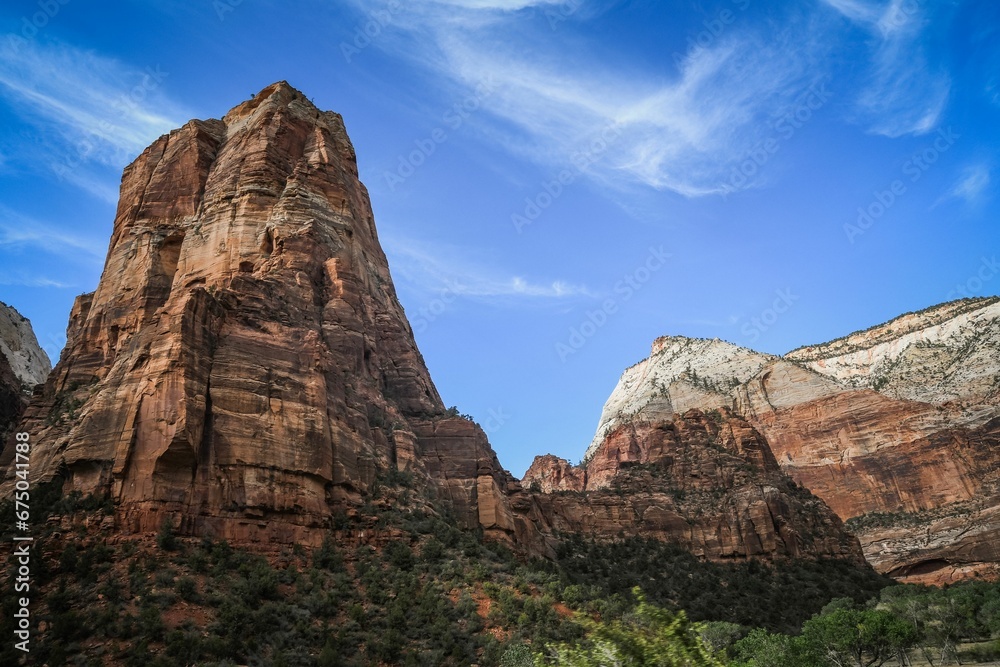 Breathtaking landscape of rocky hills against blue sky dotted with clouds, framed by lush trees Breathtaking landscape of rocky hills against blue sky dotted with clouds, framed by lush trees