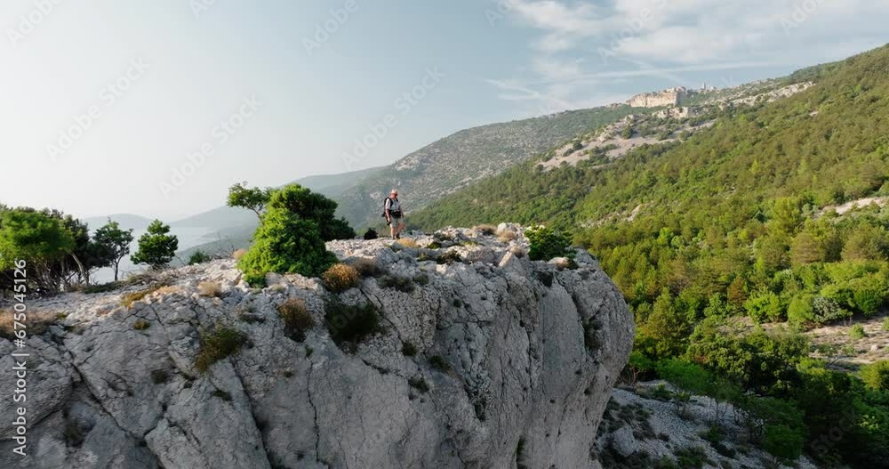 Hiker walks up to stunning overlook of Lubenice Croatia standing strong to take in scenic mountain views Hiker walks up to stunning overlook of Lubenice Croatia standing strong to take in scenic mountain views