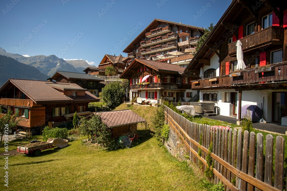 Scenic view of the Lauterbrunnen Valley in the Swiss Alps with wooden buildings surrounded by trees Scenic view of the Lauterbrunnen Valley in the Swiss Alps with wooden buildings surrounded by trees