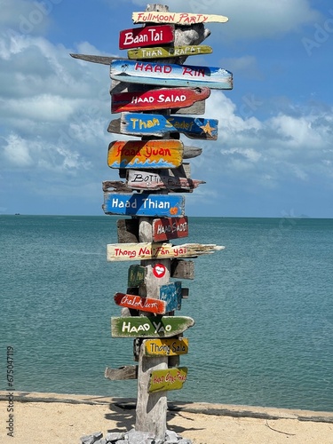 Close-up of wooden signs with text on a tropical beach in Thailand s Koh Samui