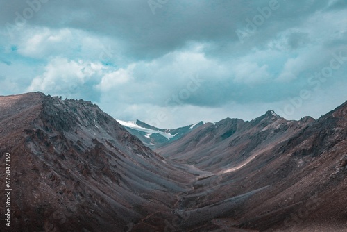 Scenic view of barren mountains under a cloudy sky