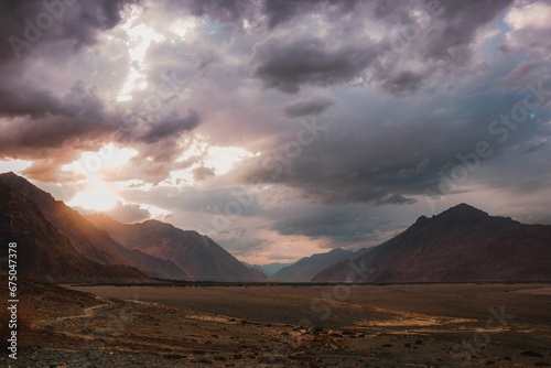 Scenic view of barren mountains under a cloudy sky