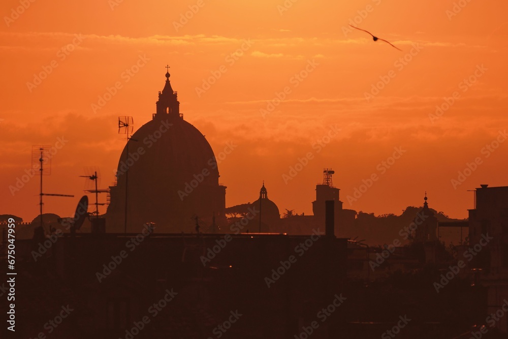 St Peter's Basilica silhouette with an orange sunset sky in the background