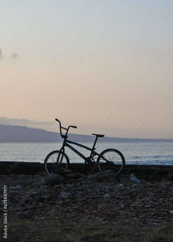 Mountain bike on the beach with the sunrise in the background.