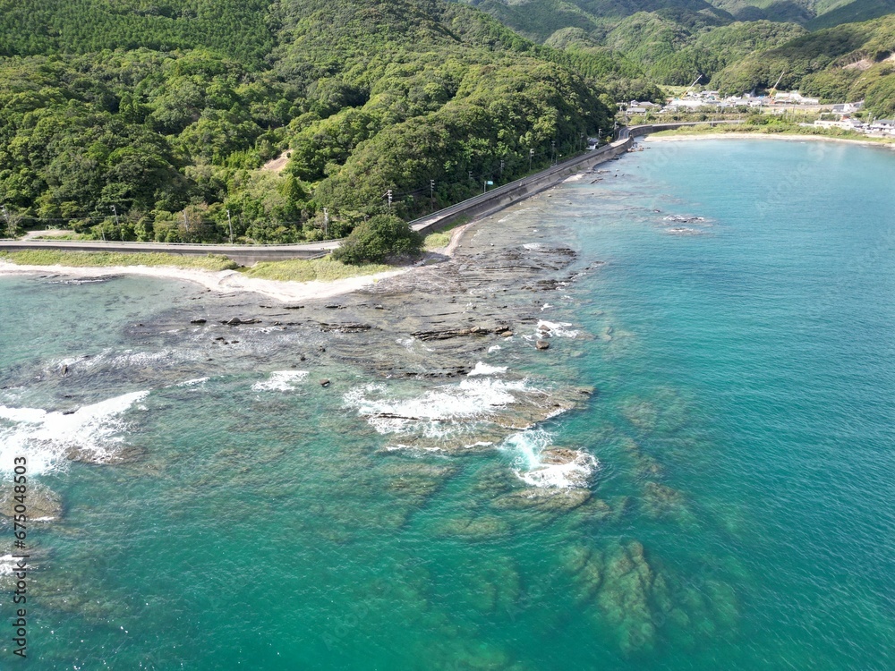 View of a coastal landscape featuring lush green mountains at the rocky ocean in Japan