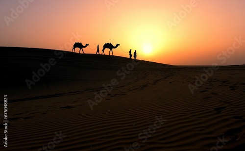 Camels and some people walking on a desert sand dune against a beautiful sunset sky  India