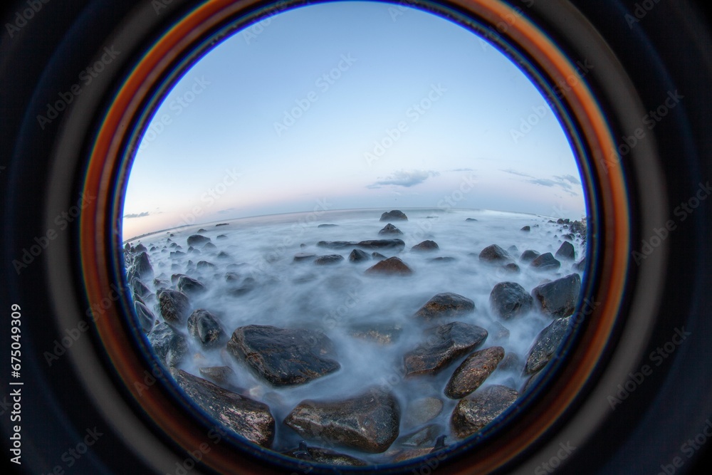 Beautiful seascape view of a sunset over the ocean with a metal pipe in the foreground Beautiful seascape view of a sunset over the ocean with a metal pipe in the foreground