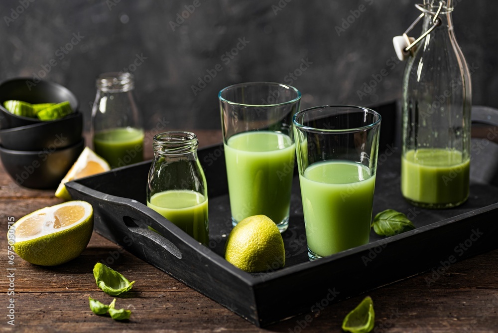 Closeup of green smoothie glasses with fruits and vegetables on a wooden surface Closeup of green smoothie glasses with fruits and vegetables on a wooden surface