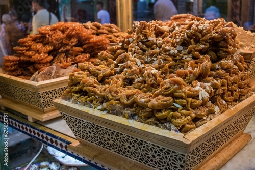 Plate full of delicious honey-glazed fried pastry sweet on display in a pastry shop in Morocco