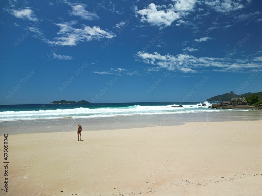 Young woman at the Lopes Mendes beach, looking out at the vast expanse of the ocean, Brazil