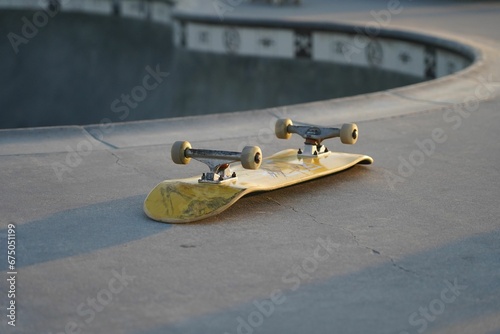Yellow skateboard lying upside down on a skate track