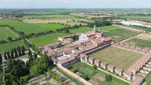 Drone footage over Certosa di Pavia monastery in Certosa Monumento with lawn fields in Italy