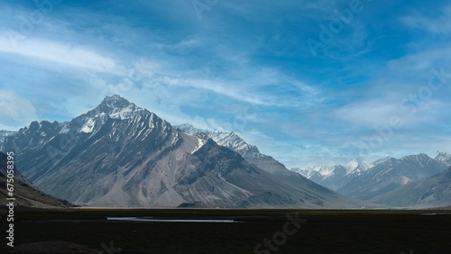 Scenic view of an expansive countryside landscape with snowy mountain peaks