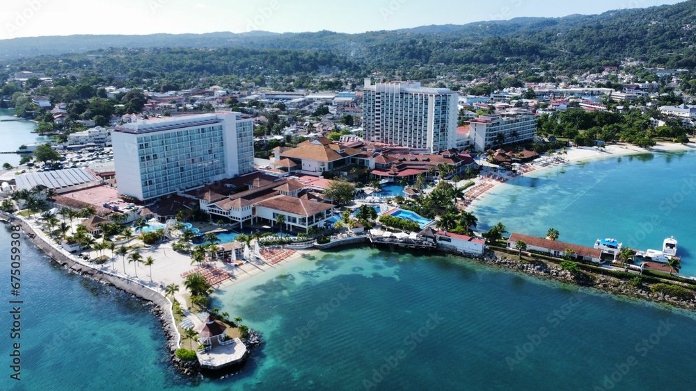 Fototapeta premium Aerial view of a tranquil bay with boats, surrounded by variety of buildings: Ocho Rios, Jamaica