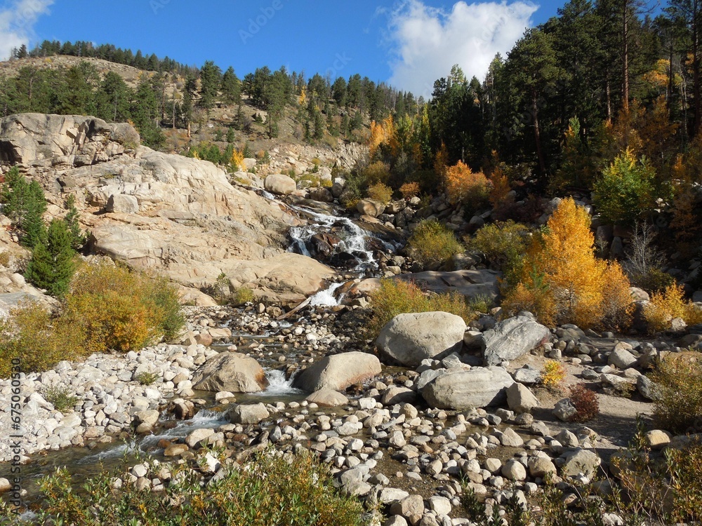 Stunning landscape view of a valley featuring rocks and a stream of water in Estes, Colorado