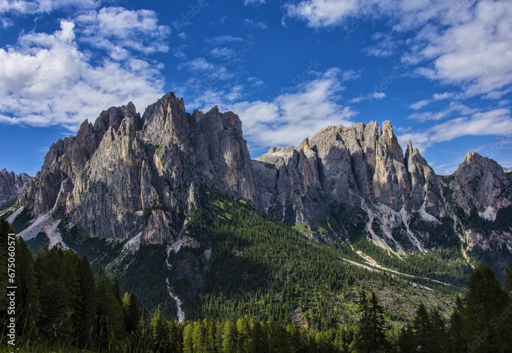 Scenic landscape of the Val di Fassa mountains and its surrounding forest in the foreground