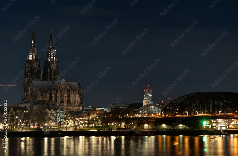 Fototapeta premium Cologne Cathedral at night with the city in the background in Cologne, Germany