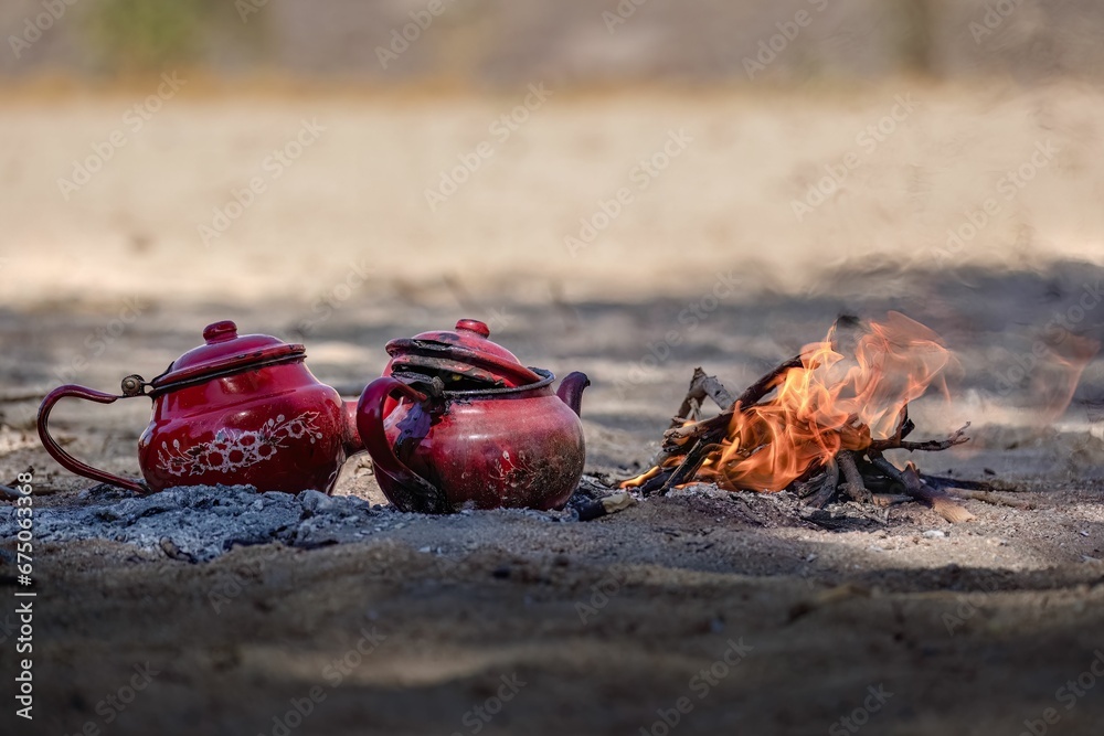 Ταπετσαρία two red teapots and some rocks sitting in front of a fire