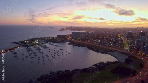 Aerial scene over the Rambla of Montevideo and Buceo port buildings by the sea at sunset, Uruguay