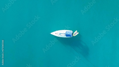 Aerial view of a single sailboat sailing through open water.
