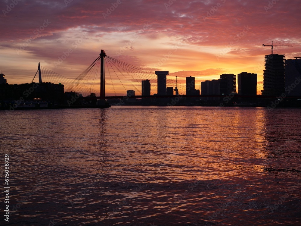 Silhouette of stunning city skyline reflected in a river at sunset