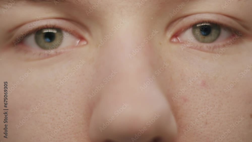 Closeup of a Caucasian person opening the beautiful green eyes and looking at the camera Closeup of a Caucasian person opening the beautiful green eyes and looking at the camera