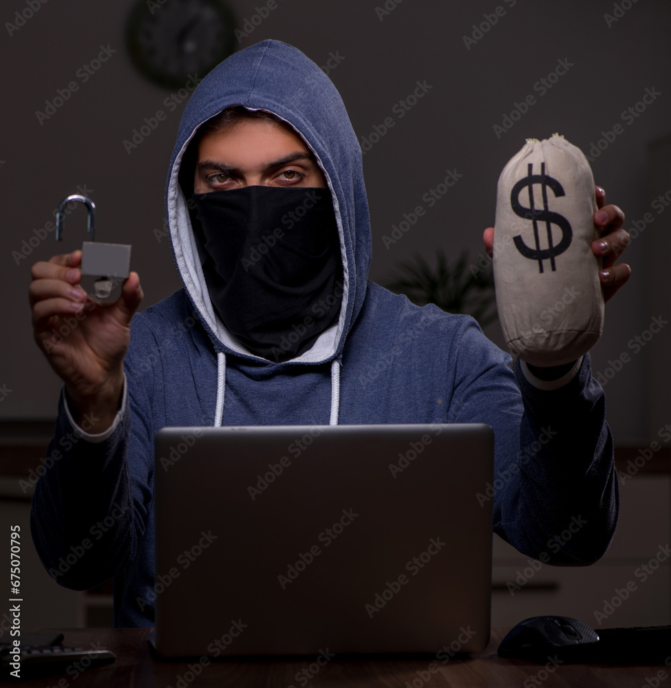 Male hacker hacking security firewall late in office Male hacker hacking security firewall late in office